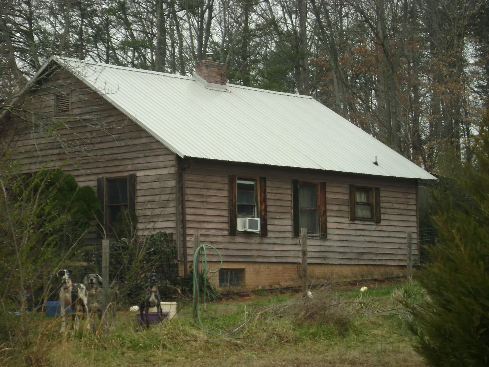 White metal roof on an old wood sided farmhouse, from a Metal Roof Installation job in Austin